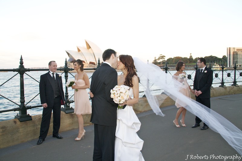 Couple Kissing with attendants around Sydney Opera House - wedding photography sydney